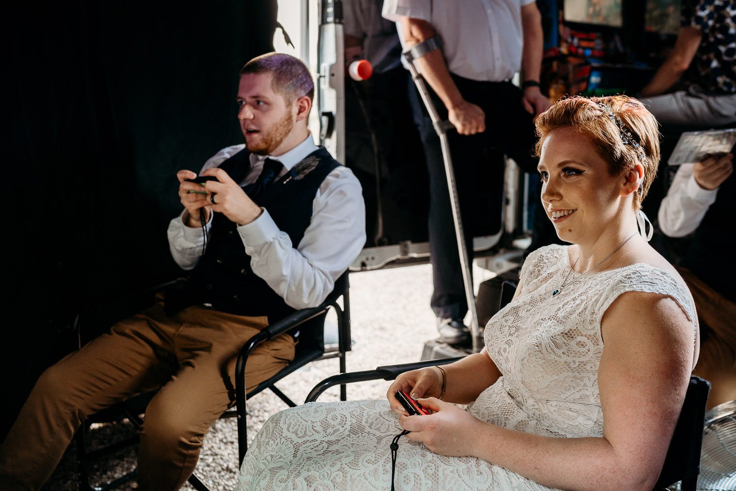 bride and groom playing video games at their quirky wedding reception