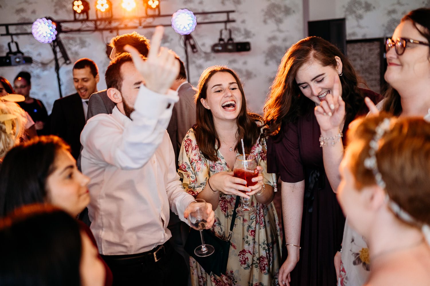 wedding guests dancing and laughing during wedding reception