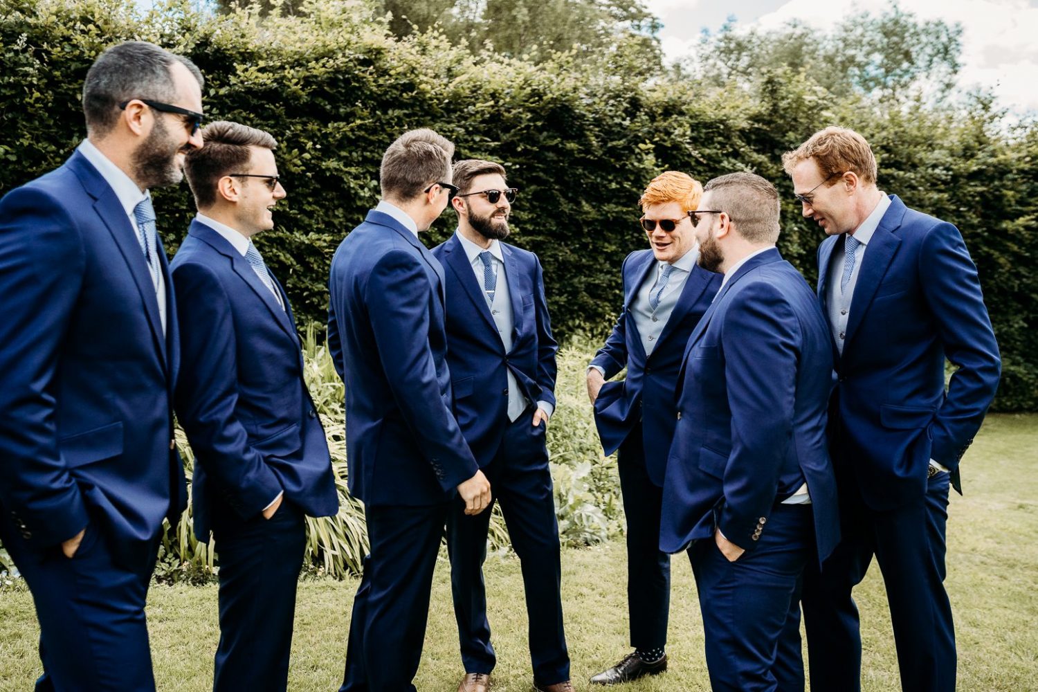 groom and groomsmen laughing outside st marys church somerset