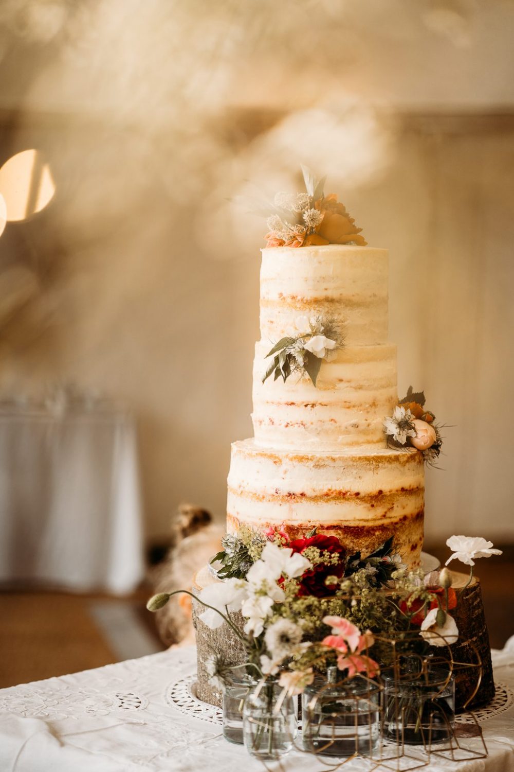 white naked wedding cake in tipi at the manor somerset