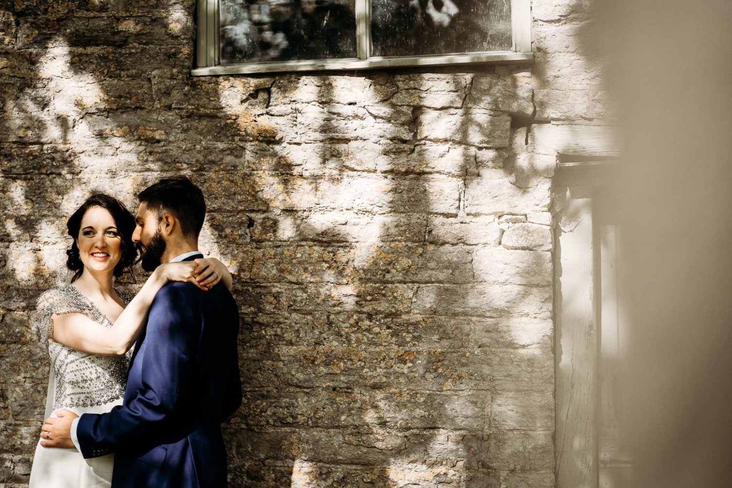 bride in art deco style wedding dress hugging groom