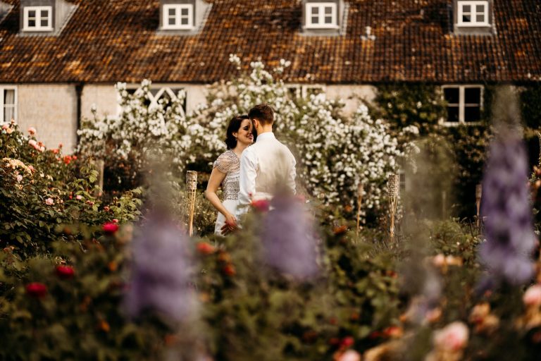 bride and groom in overgrown floral garden