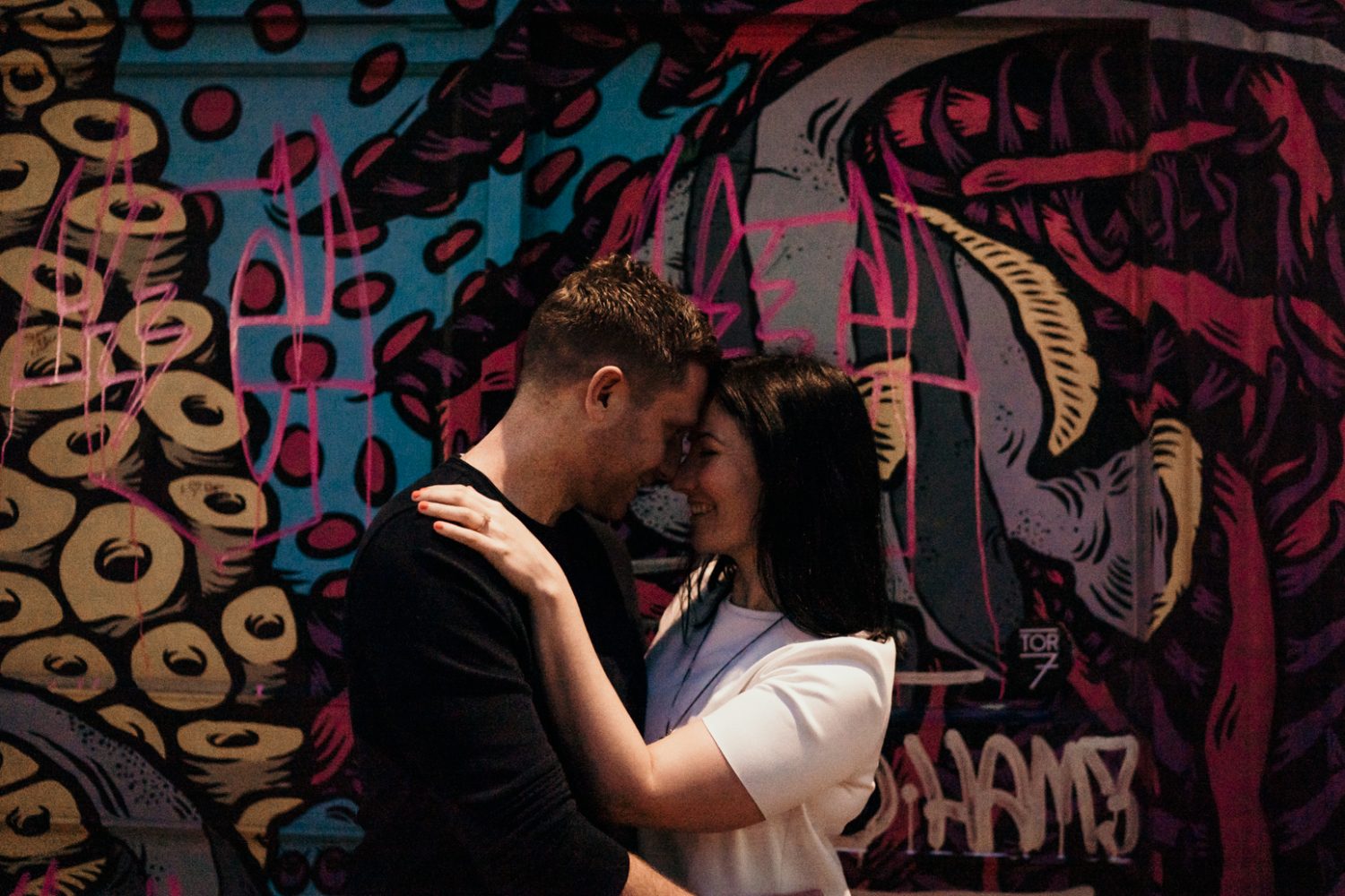 bride and groom hugging outside of graffiti wall in bristol