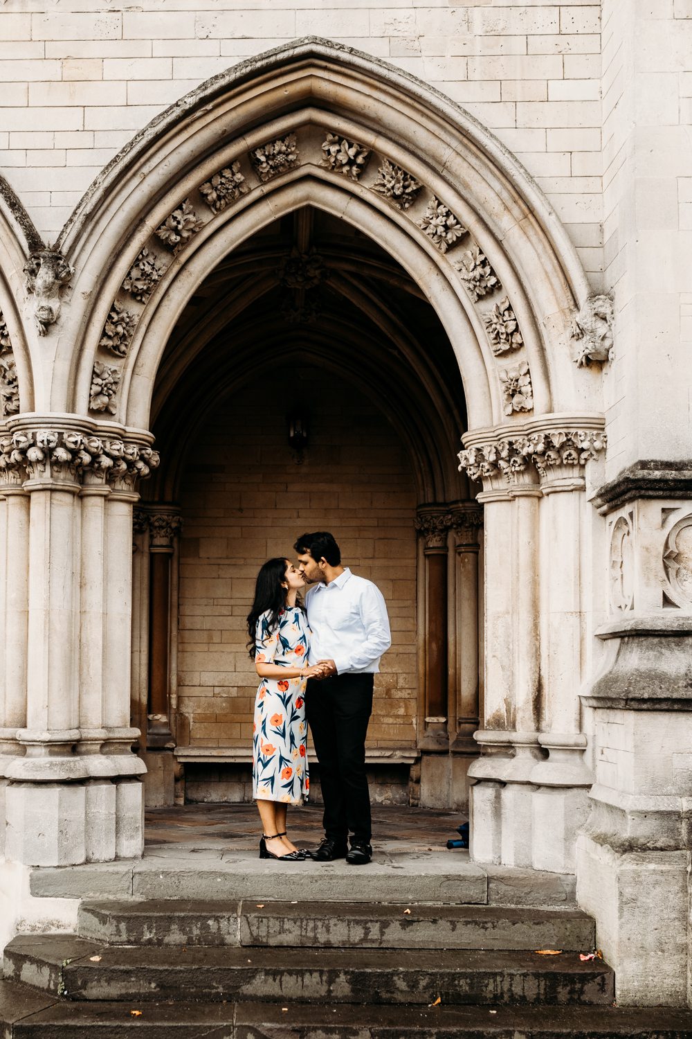 engaged couple share a kiss on steps in bristol