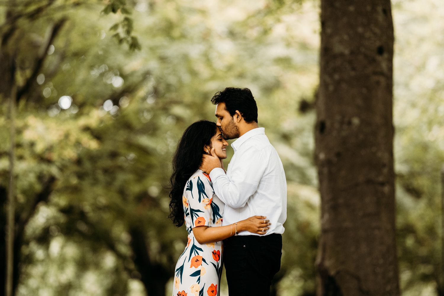 candid photo of man kissing lady on forehead after engagement in bristol