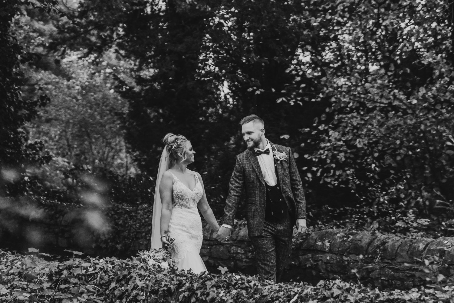 bride and groom walking on bridge at Miskin manor